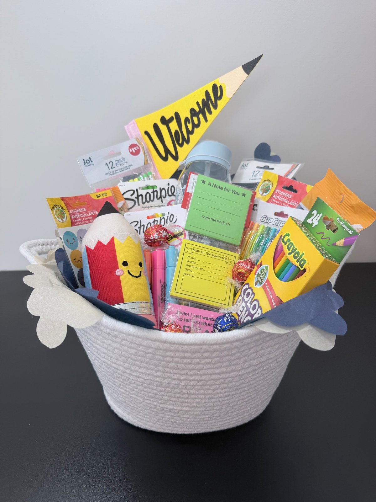 Signature Collection welcome basket filled with school and desk supplies, a plush pencil, water bottle, and chocolates